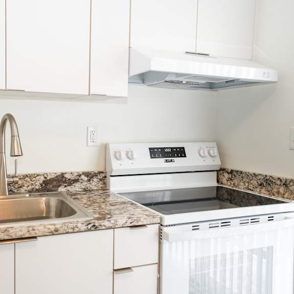a kitchen with a white oven and sink.