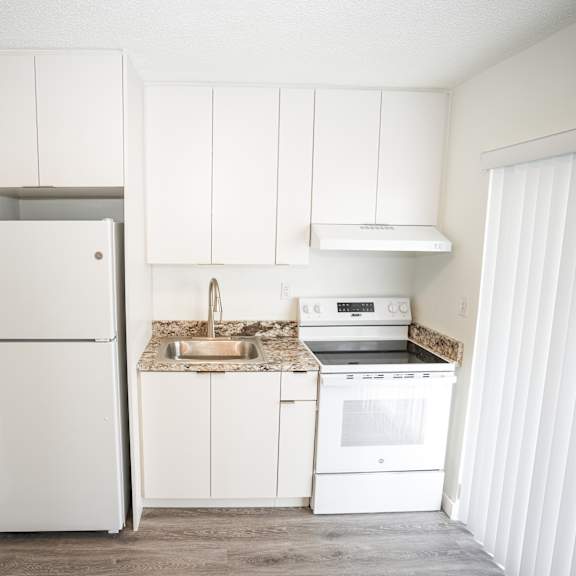 a kitchen with white appliances and cabinets.