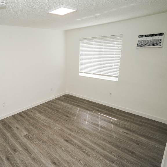a room with a window and wooden flooring.