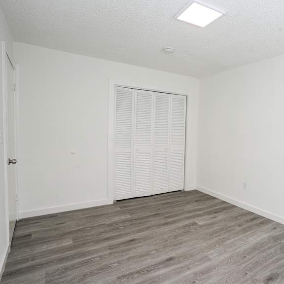 a room with a white door and a window with blinds.