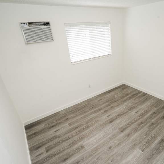 a room with a window and wooden flooring.