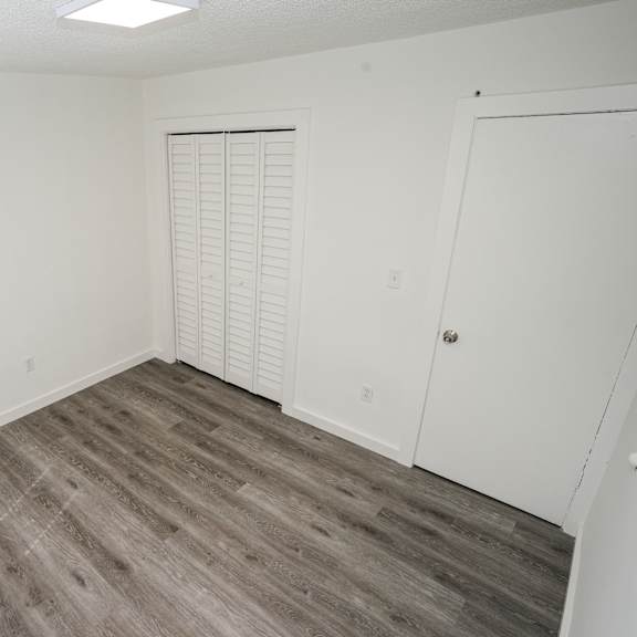 a room with a wooden floor and white walls.