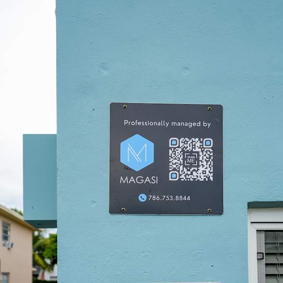 a sign on a building that says "professionally managed by magasi" with a phone number.