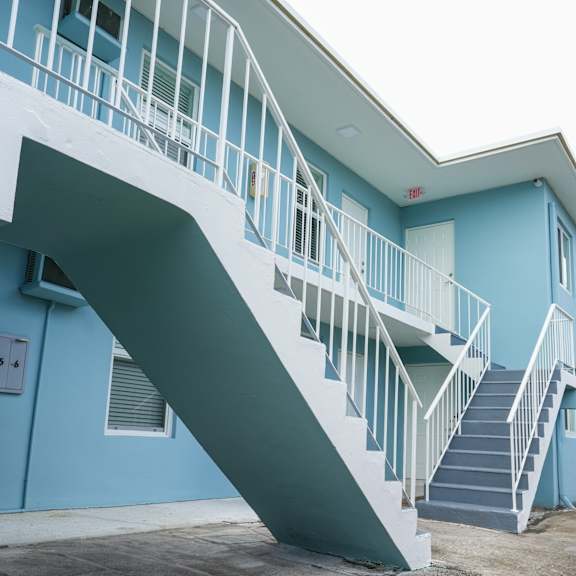a blue building with a white staircase.