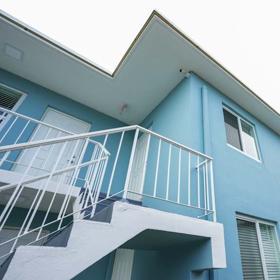 a blue house with a white balcony.