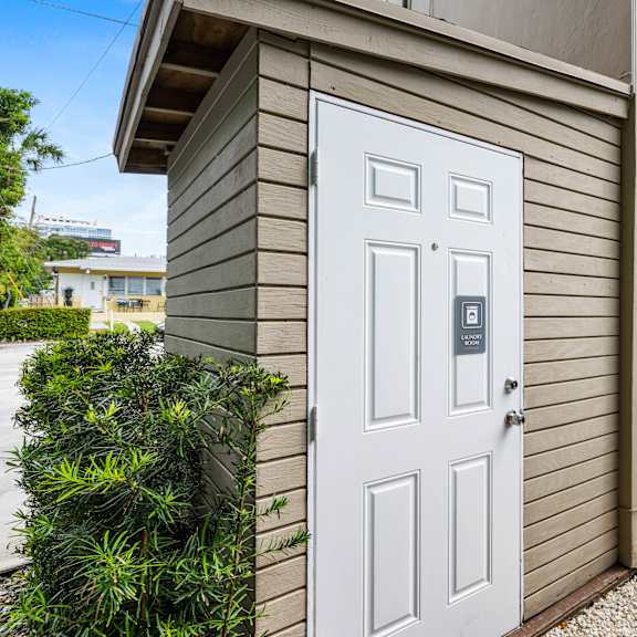 a white door with a black handle is on a beige house.