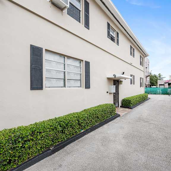 a long, narrow building with a green bush on the side.