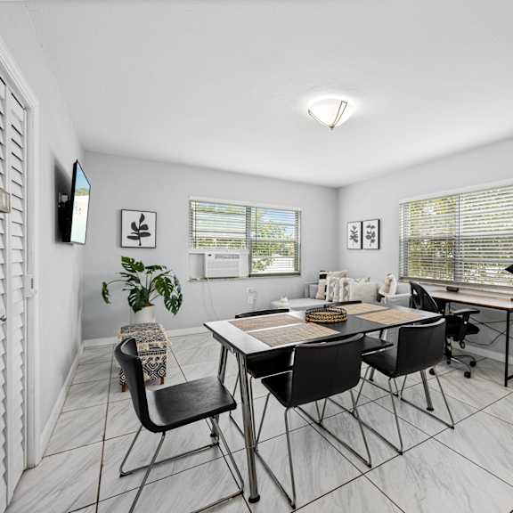 a room with a table and chairs and a potted plant.