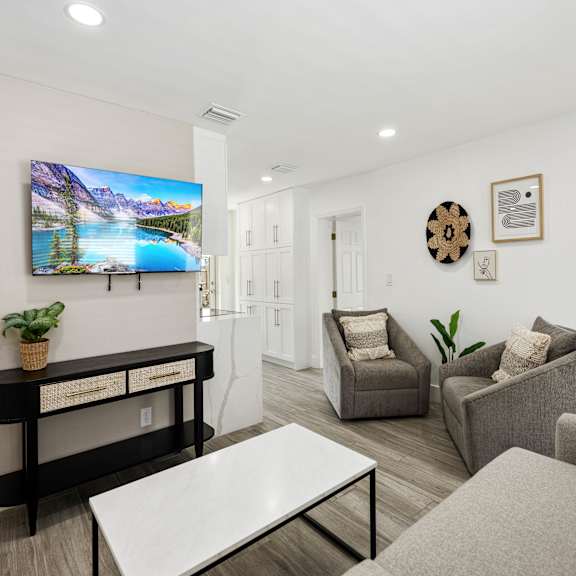 a living room with a flat screen tv mounted on the wall.