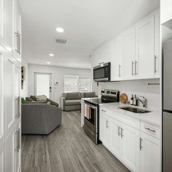 a modern kitchen with white cabinets and a stainless steel refrigerator.
