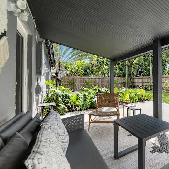 a patio with a black table and chairs.