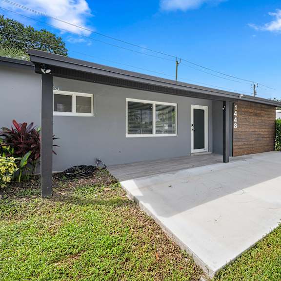 a grey house with a black door and a grey roof.
