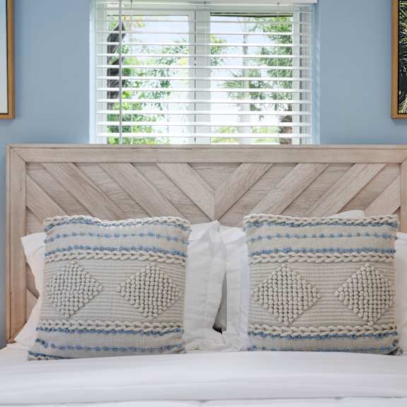 a bed with two pillows and a white headboard.