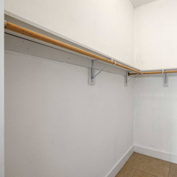 a white wall with a brown bar and silver brackets.