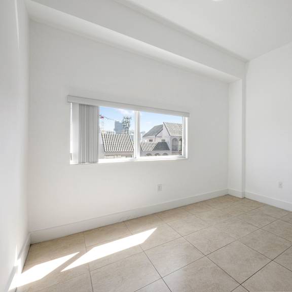 a room with a window and tiled floor.