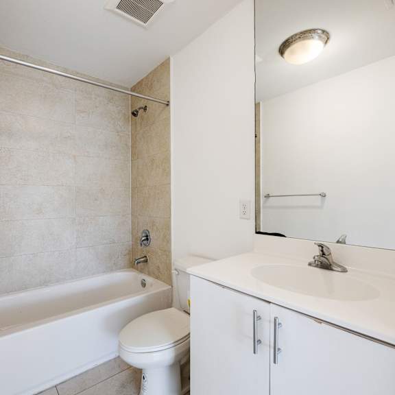 a white bathroom with a toilet, sink, and bathtub.