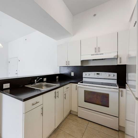 a kitchen with white cabinets and a black countertop.