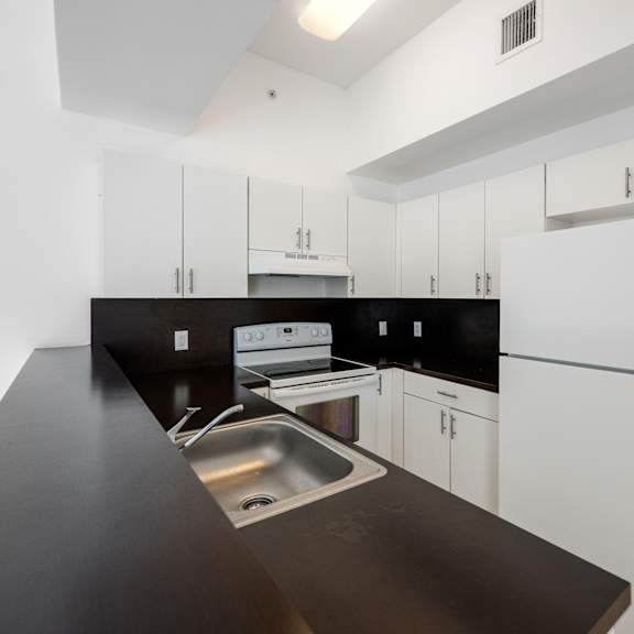 a kitchen with black countertops and white cabinets.