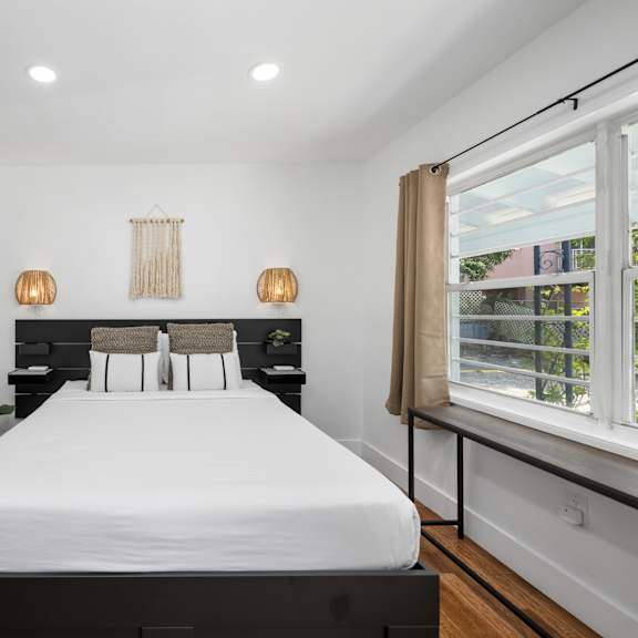 a bedroom with a large bed and a window with a view of the outside.