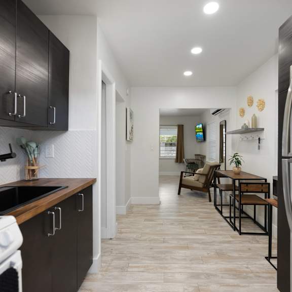a modern kitchen with a stainless steel refrigerator and wooden cabinets.