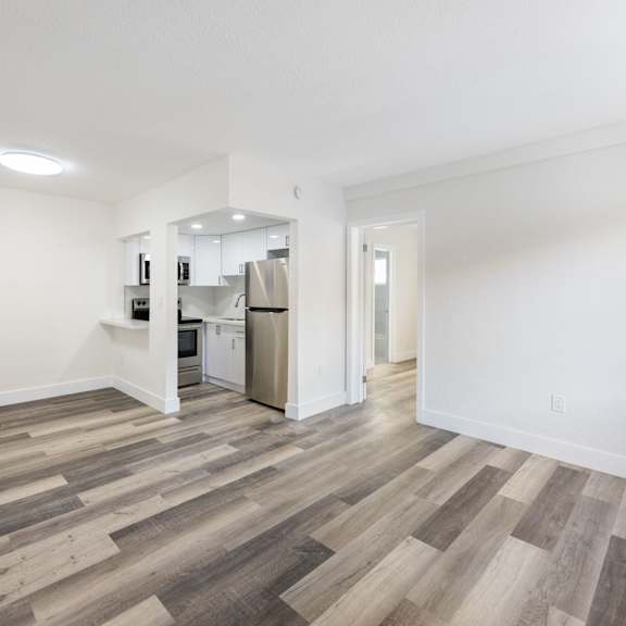 a kitchen area with a refrigerator, microwave, and oven.