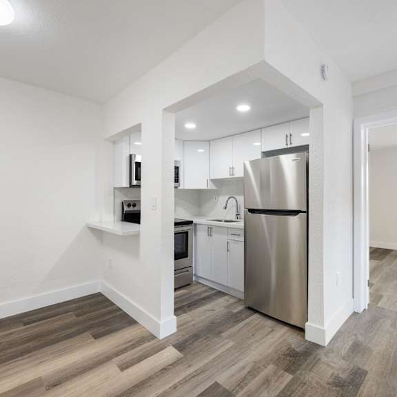 a kitchen with a refrigerator, microwave, and oven.