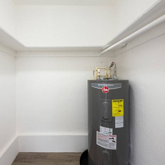 a water heater is in a corner of a room.