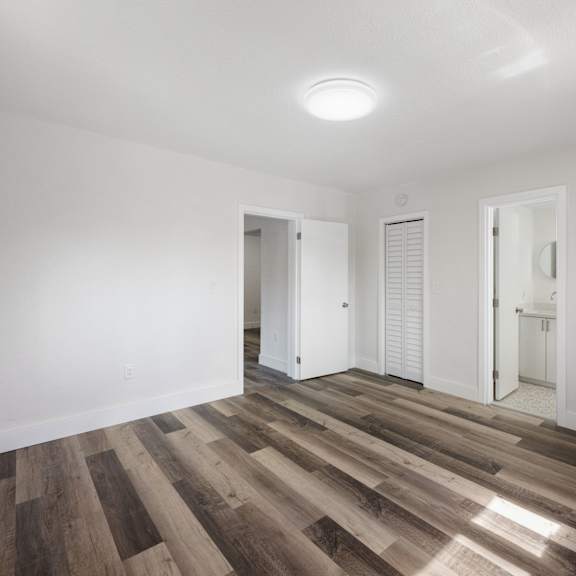 a room with wooden flooring and white walls.