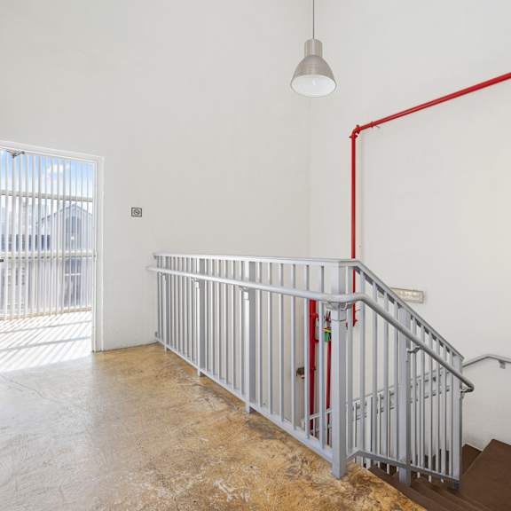 a red pipe runs along the wall of a white room.