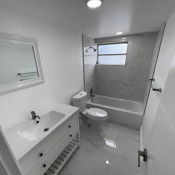 a white bathroom with a sink, toilet, and bathtub.