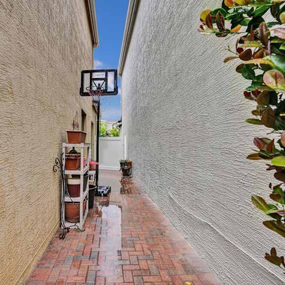 a brick pathway leads to a basketball hoop.