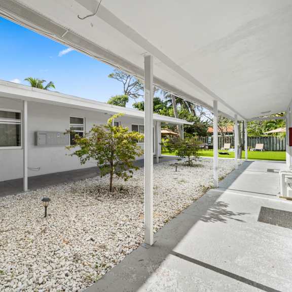 a white building with a gravel area in front.