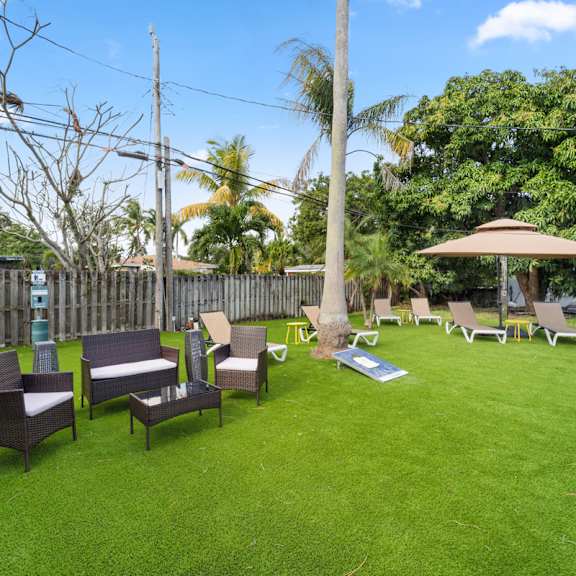 a backyard with a lawn and patio furniture.