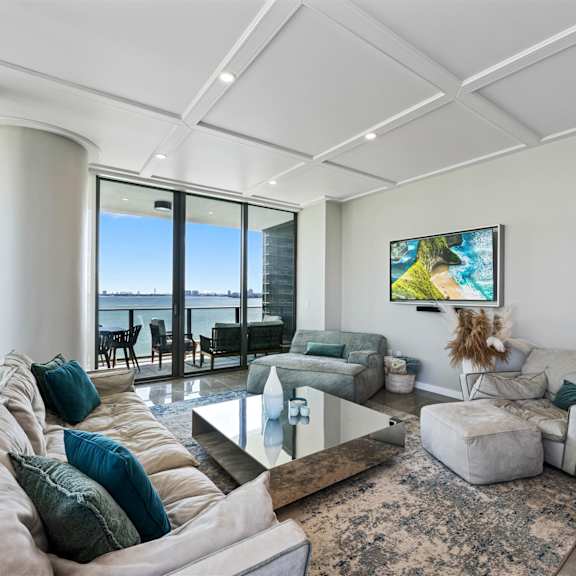 a living room with a large window and a painting on the wall.