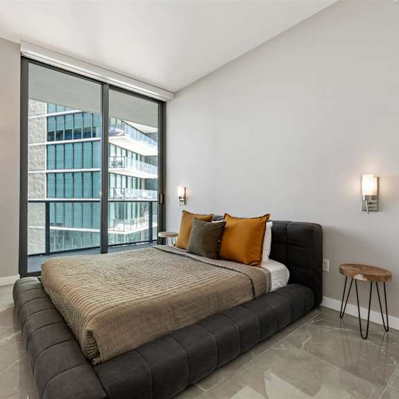 a bedroom with a large bed and a floor lamp.