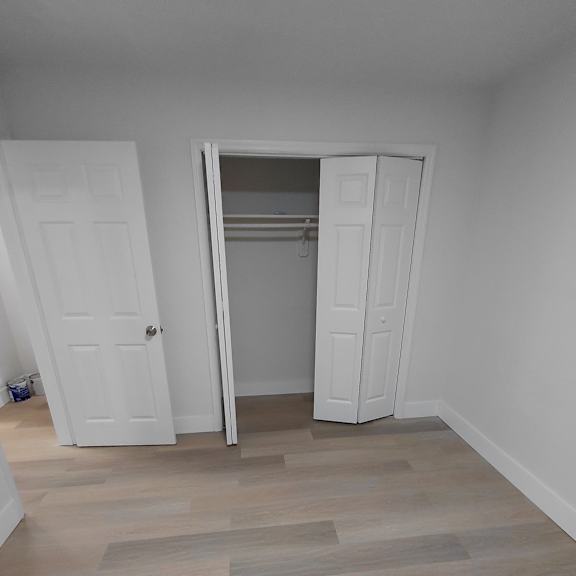 a room with a white door and a white closet with a white interior.