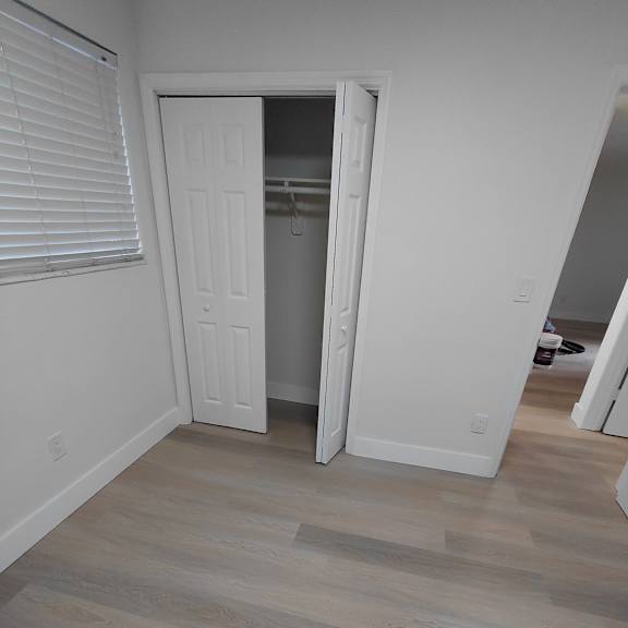 a room with a white door and a wooden floor.