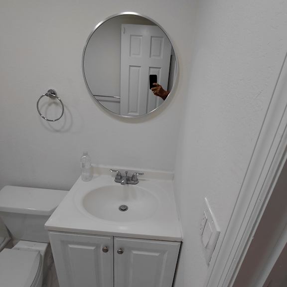 a bathroom with a white toilet, sink and cabinet.