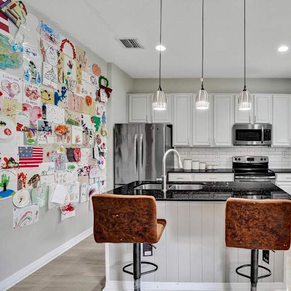 a kitchen with a black counter top and white cabinets.