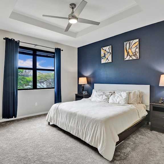 master bedroom with garden view, accent wall and artwork.