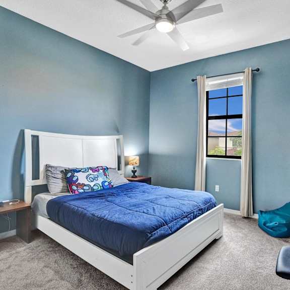 child room with garden view, bright natural light and ceiling fan.