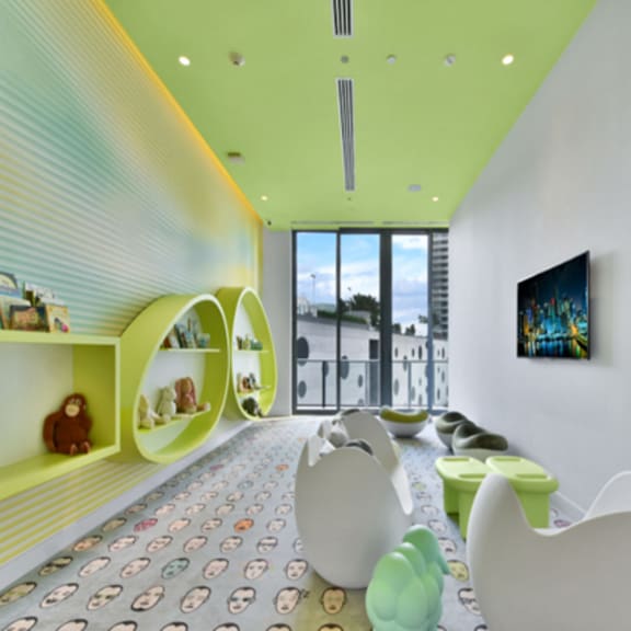 a brightly colored children's playroom with white chairs and a green floor.
