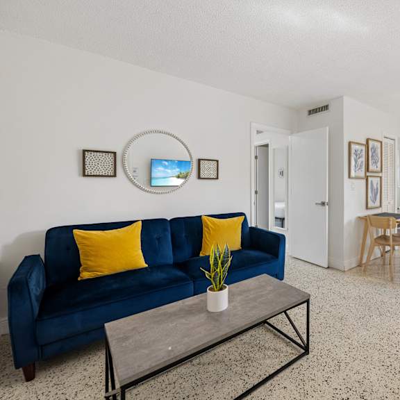 a living room with a blue couch and a coffee table.