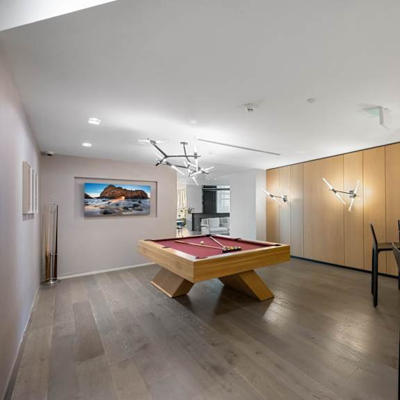 a room with a pool table and a painting on the wall.