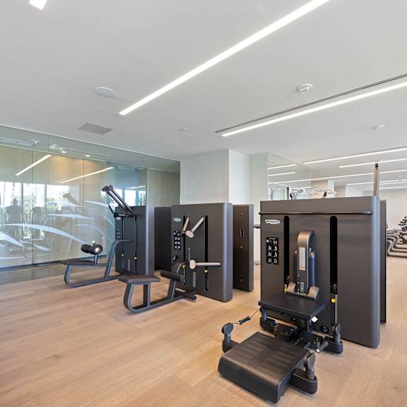 a gym with treadmills, exercise bikes, and elliptical machines.