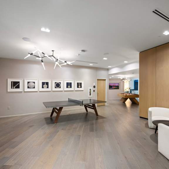 a room with a ping pong table and chairs.