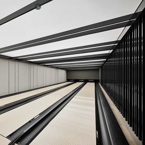 a long, narrow corridor with a reflective floor and walls.
