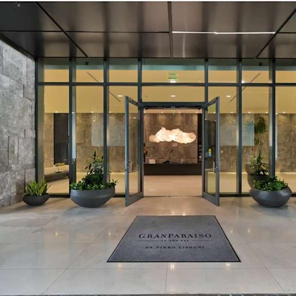 the entrance to a building with a stone wall and a glass door.