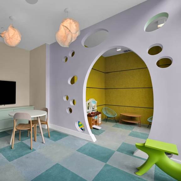 a room with a television, chairs, and a table.