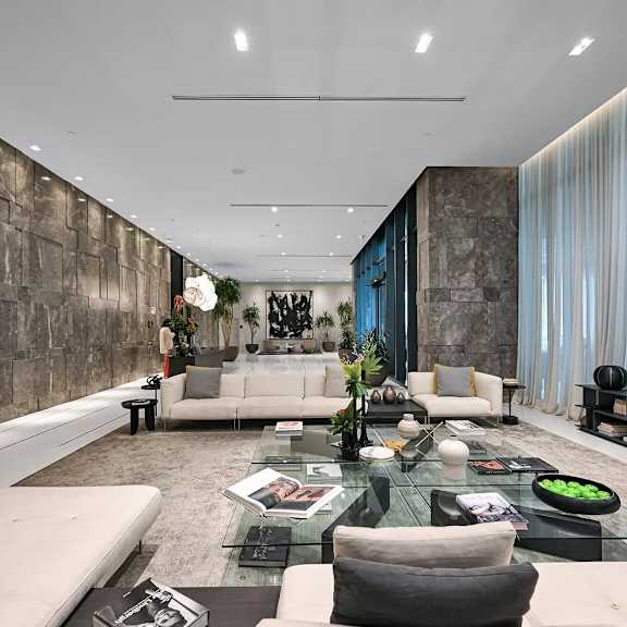 a modern living room with a glass table and white couches.
